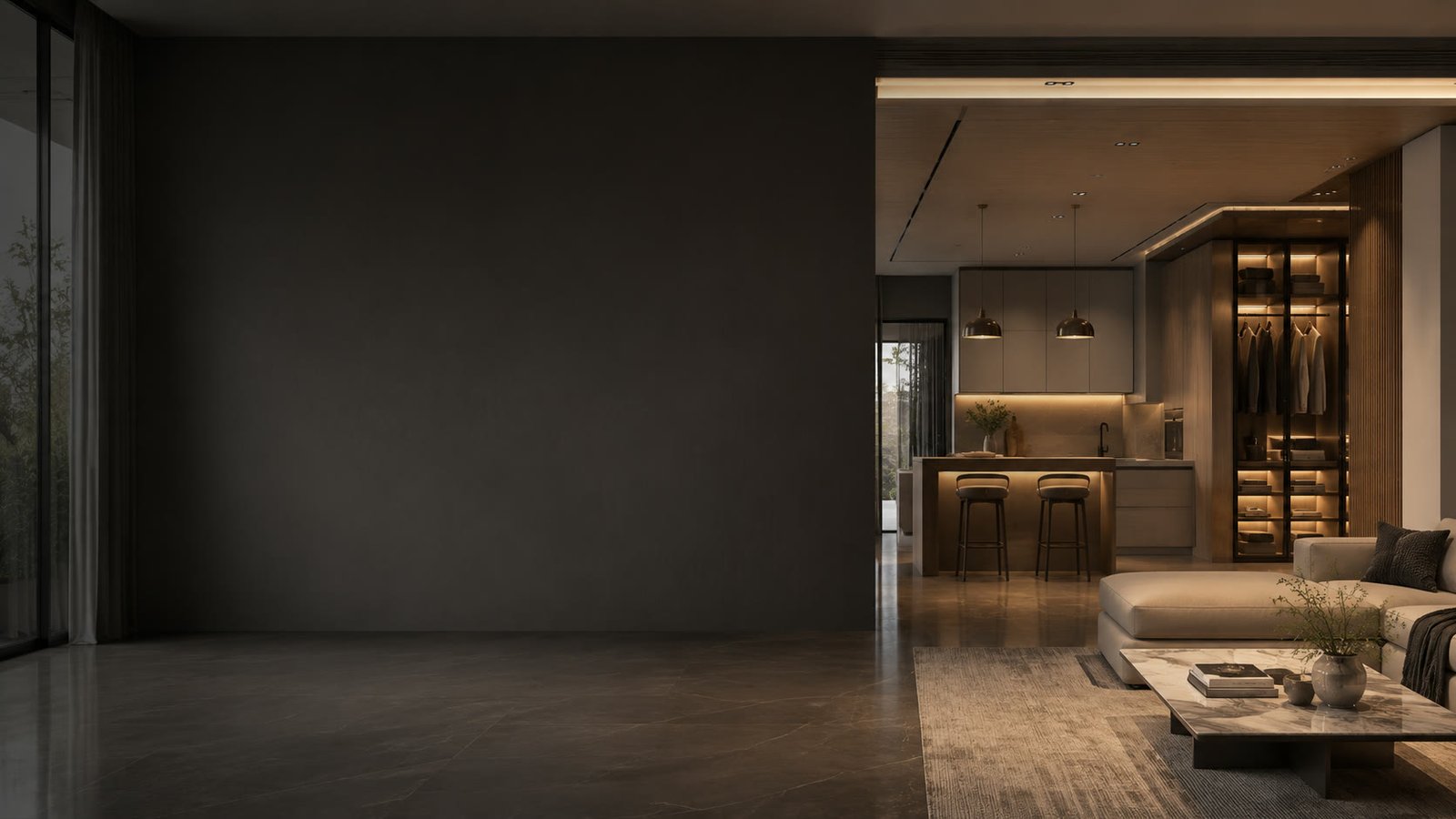 An empty, dimly lit living room; through the opening, a finished kitchen and lit wardrobe